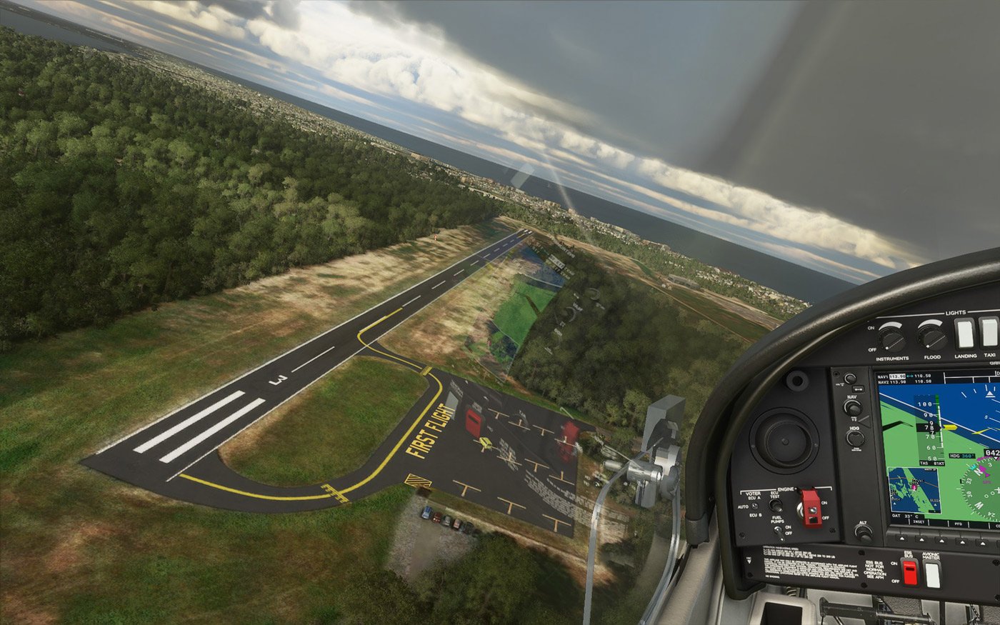 Aerial view from the cockpit on final approach to First Flight Airport (KFFA) runway in Kill Devil Hills, NC, with the Atlantic coastline visible beyond